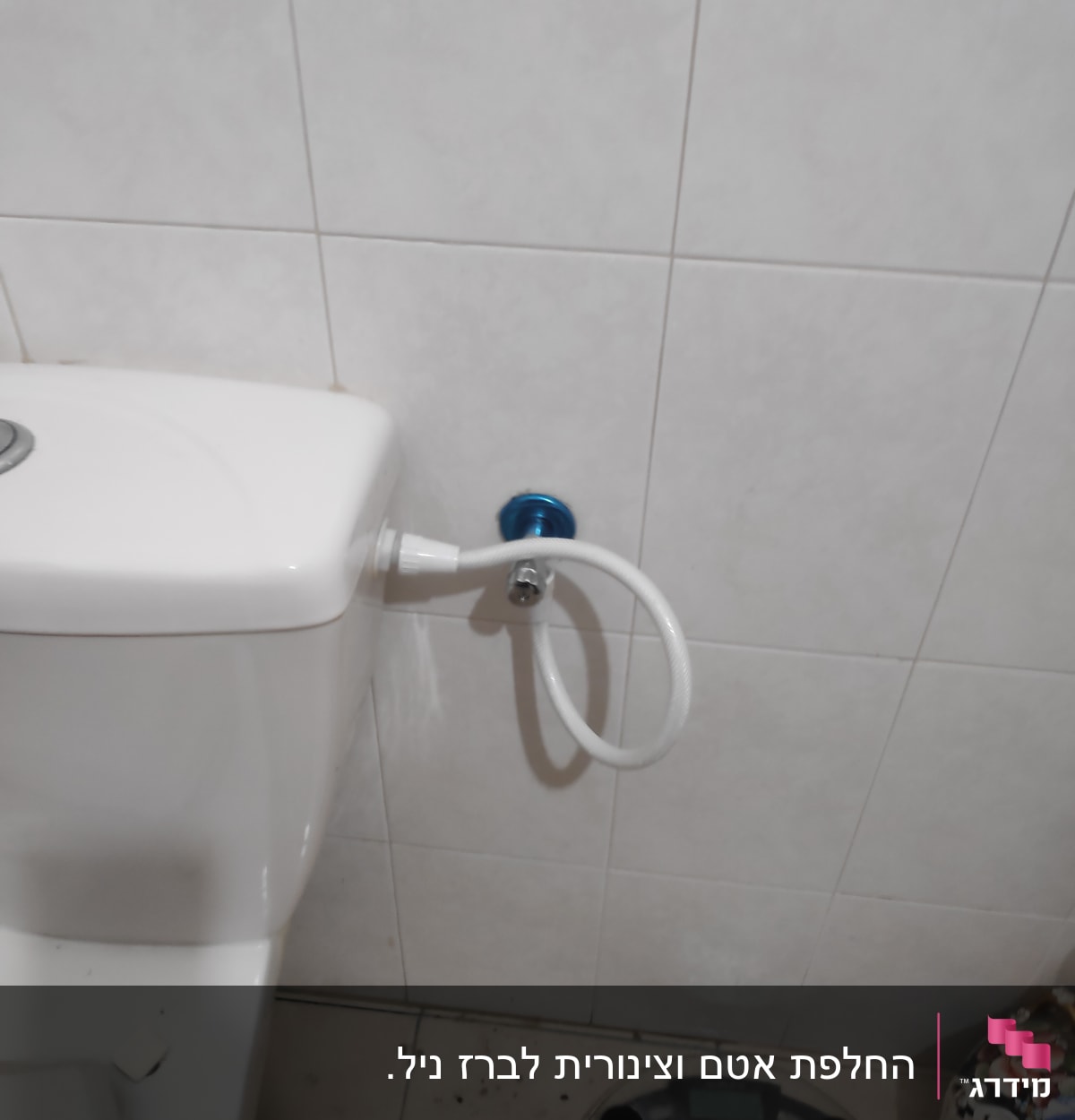 אסלה עם צינור מים מחובר לקיר